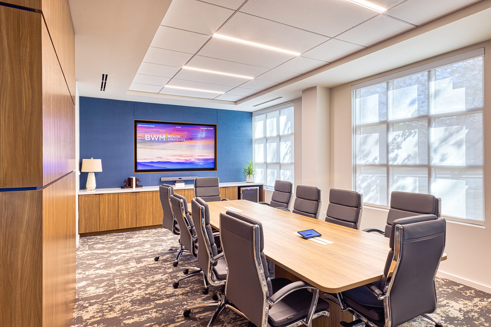 Modern conference room at BWM Wealth Strategies in Charlotte, NC, featuring natural wood finishes, blue accents and abundant daylight by Ossa Studio.