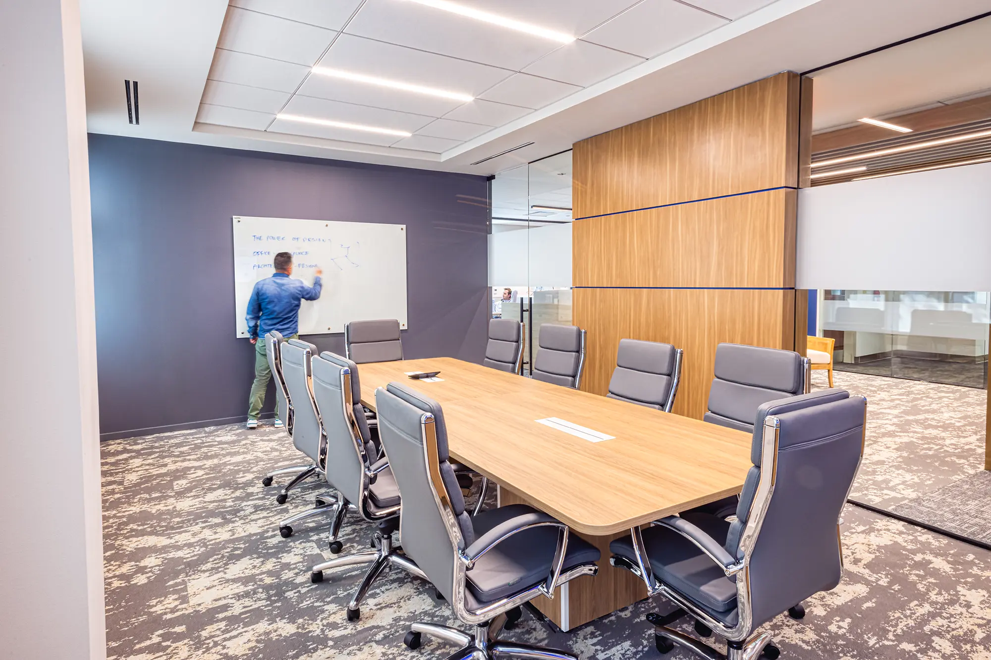 Conference room at BWM Wealth Strategies in Charlotte, NC, featuring a wood table, glass walls and custom wood detailing by Ossa Studio.