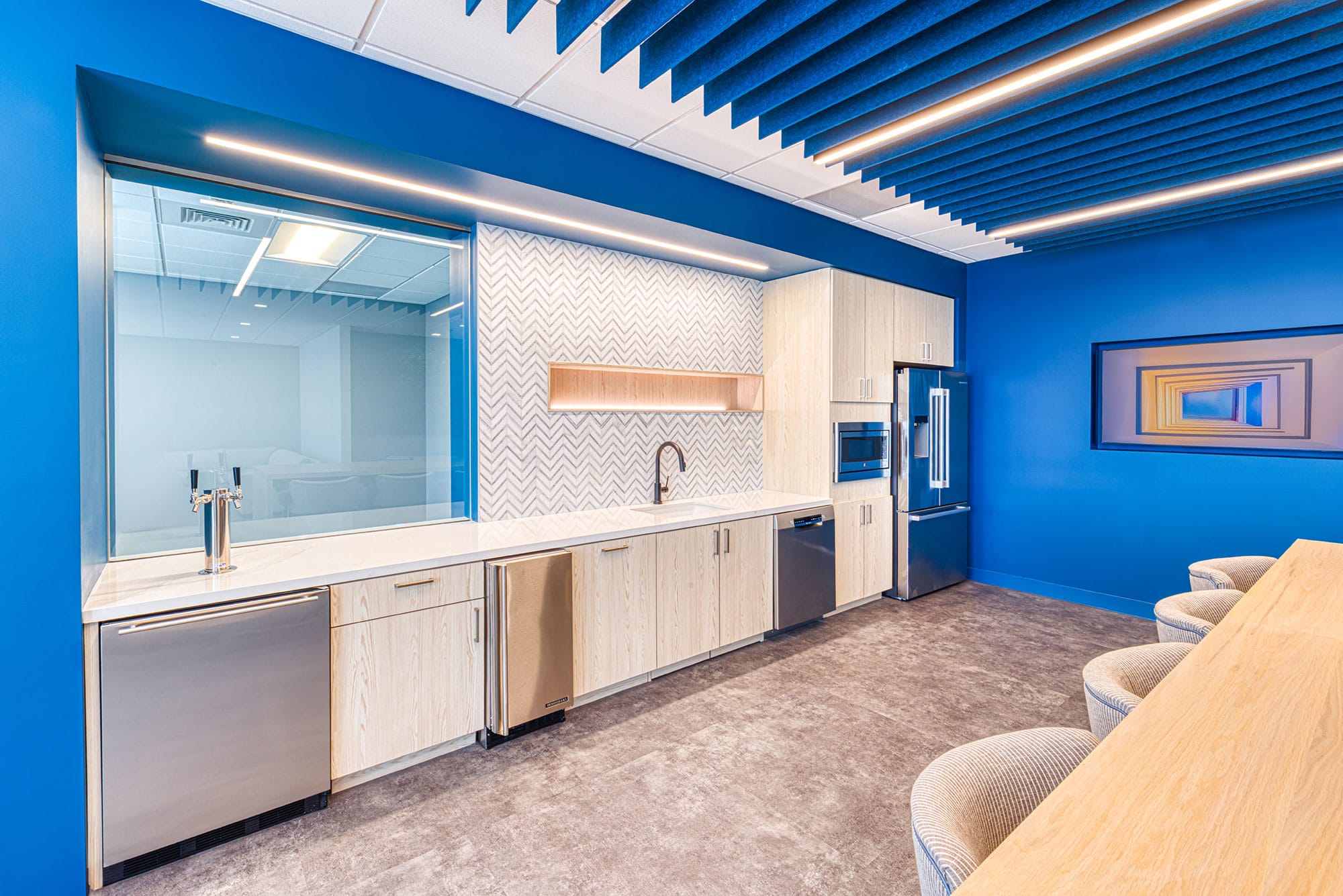 Kitchen detail at the Collet office in Charlotte, NC with beverage taps, chevron tile, light wood cabinets and appliances by Ossa Studio
