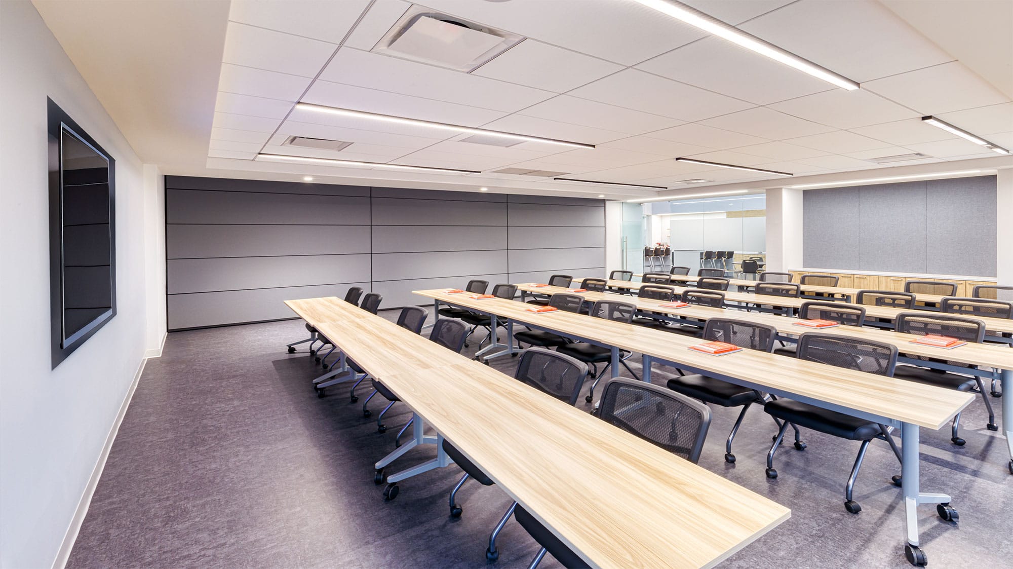 Crowder Construction training room in Charlotte, NC with light wood tables and the movable partition closed, by Ossa Studio