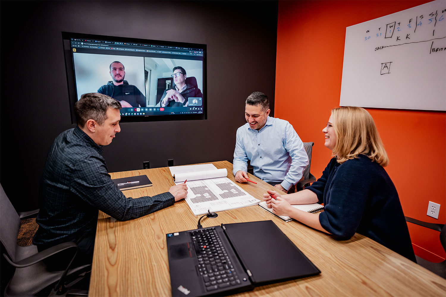 Jack Ossa and the Ossa Studio team reviewing plans in a meeting room