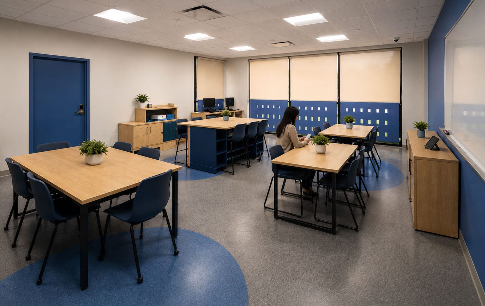 Classroom at Melmark Carolinas school in Charlotte, NC with wood tables, blue accents and daylight windows by Ossa Studio