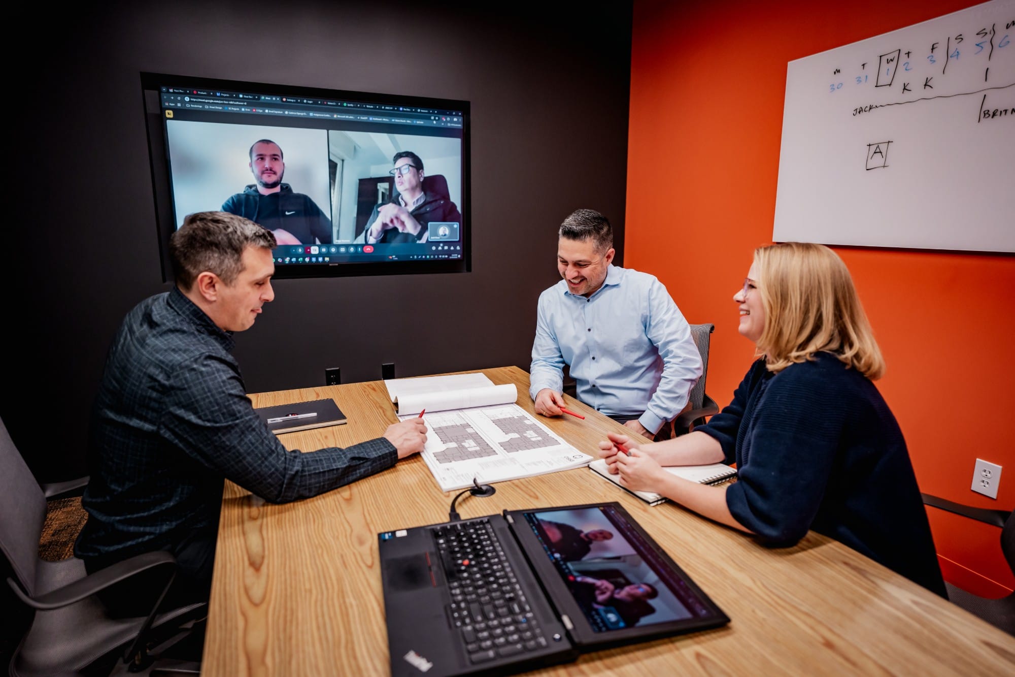 Ossa Studio team reviewing floor plans with remote colleagues on a video call