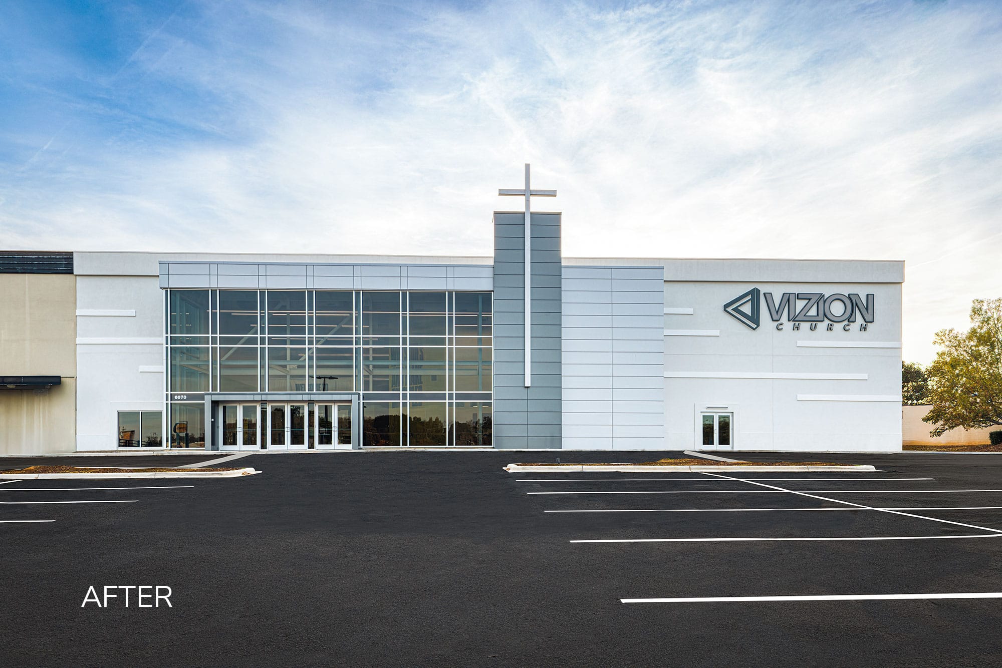 After: Vizion Church in Charlotte, NC, the transformed commercial building with glass entrance and cross tower by Ossa Studio